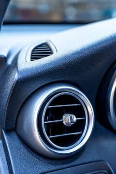 Close-up of modern car air vent on textured dashboard