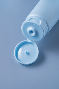 Minimal blue cosmetic cream tube with open flip cap closeup