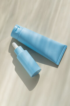 Minimal blue cosmetic packaging with serum bottle and tube