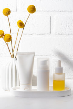 White skincare cosmetics set with serum dropper on tray