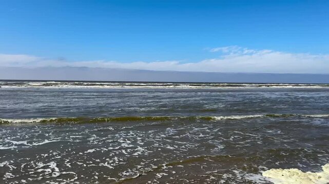 Ocean waves, 4K video of the blue ocean water waves of the North Sea outdoor at daytime during springtime season along he coast of Noordwijk aan Zee in The Netherlands.