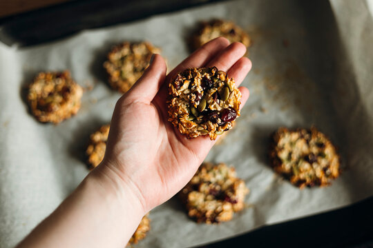Homemade sugar-free seed cookie held in hand, closeup