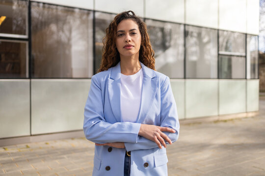 Confident businesswoman standing outside modern office building