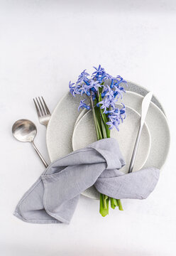 Minimal table setting with hyacinth bouquet and linen napkin