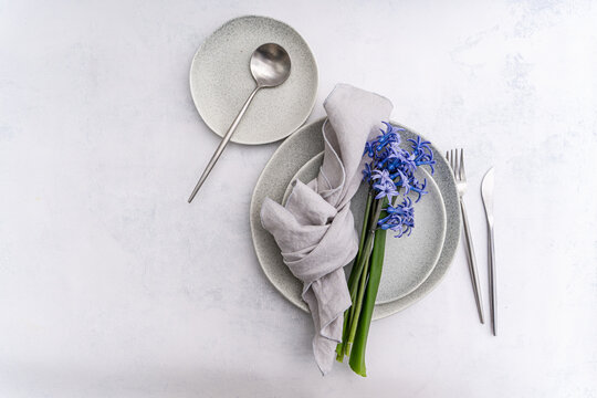 Minimal table setting with blue hyacinth and linen napkin