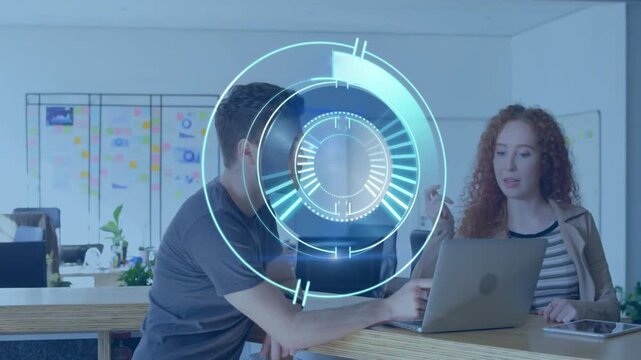 Male leaning on counter pointing at laptop, HUD appearing, female typing, refining business plan