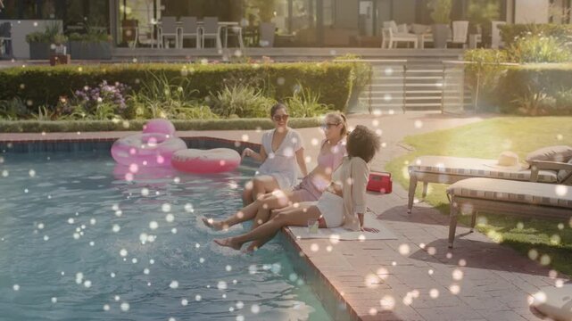 Three women starting chat gently kicking pool water cooling donut bokeh on splashes for lifestyle