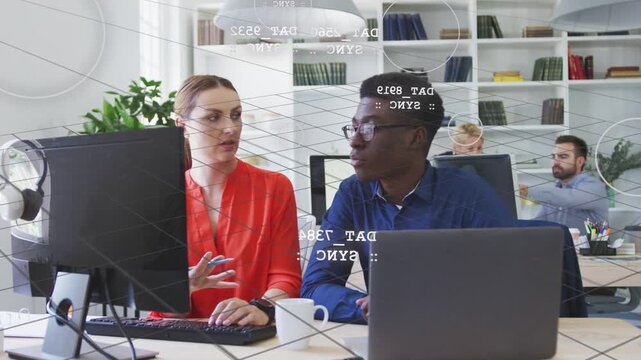 Woman in red typing, explaining; man in blue pointing at monitor, office overlay highlighting data