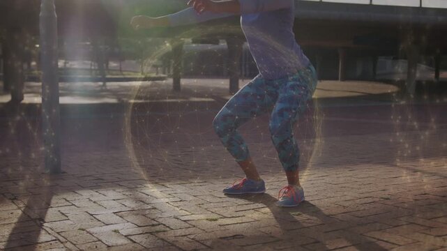 Woman starting workout, performing repeated squats on brick plaza with lens flare accenting fitness