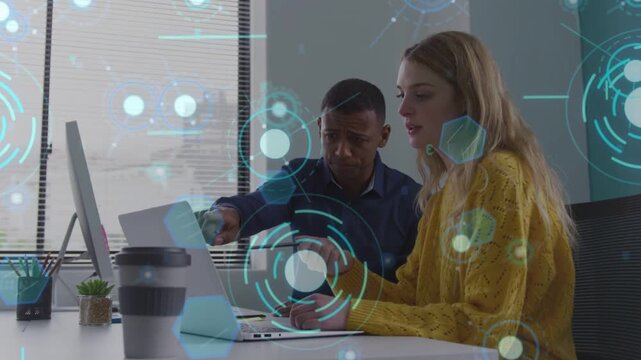 Woman typing at laptop, speaking, male leaning and pointing, HUD overlaying data for tech to align
