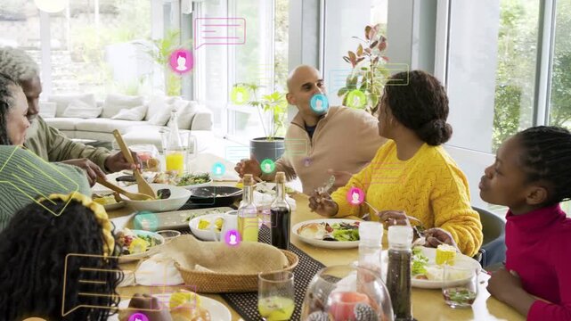 Older man serving, camera panning, family sharing meal, social media icons floating over plates