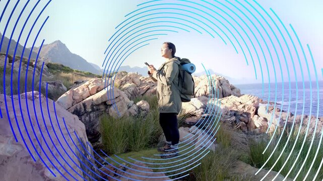 Hiker checking phone, activating ring overlay, raising hand and scanning horizon for travel