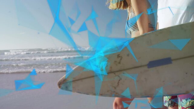 Grabbing boards couple walking shore to surf filming travel, blue triangle overlay tracking steps