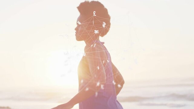Woman lowering hands, walking along sunlit shore while currency overlay tracking head for balance
