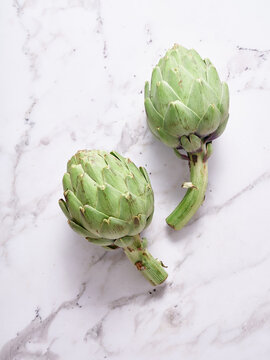 Fresh artichoke on marble background, minimal food flat lay