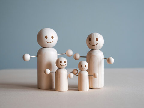 A group of four wooden human figures with smiles on their faces