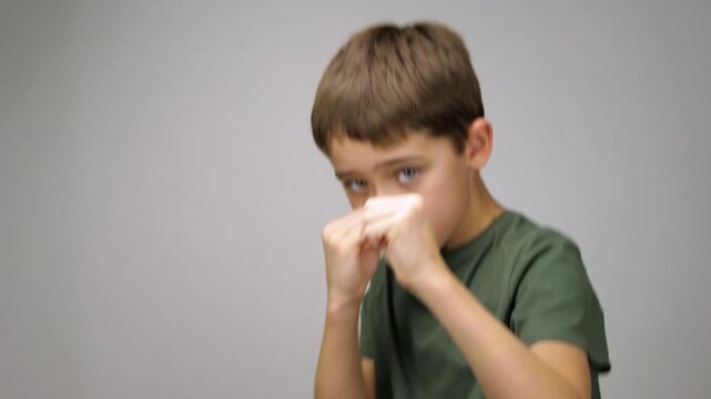 Boy practicing boxing punches in training studio, focused and determined during workout. Concept of youth sports, discipline and self development, active lifestyle, skill building, energetic training