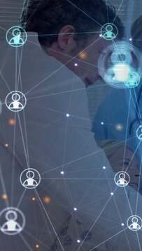 Vertical video: Doctor leaning over patient and talking, medical overlay icons shifting over staff