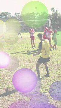 Vertical video: Soccer player in yellow running shooting to score wall jumping lens flare obscuring