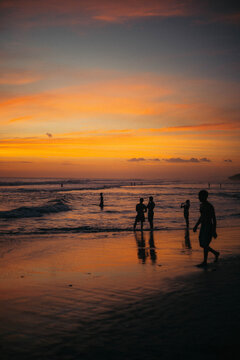 people in the ocean at sunset time