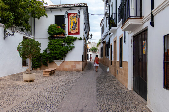 Woman walking in narrow white street in Andalusia town