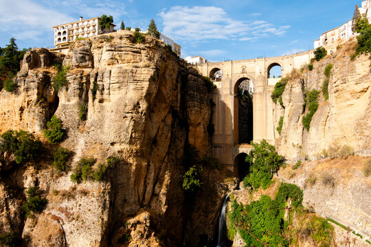 Historic bridge over canyon with waterfall in Ronda Spain