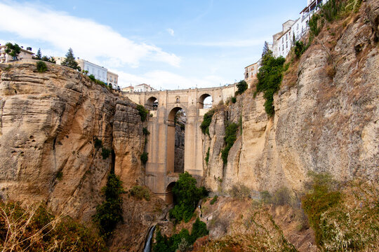 Historic bridge over canyon with waterfall in Ronda Spain
