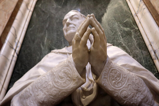 Monumento a Papa Benedetto XV in preghiera, scultura in marmo bianco e bronzo nella Basilica di San Pietro in Vaticano, concetto di pace e fede cattolica