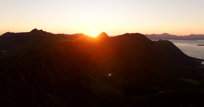 Cinematic sunset over Storheia mountain in Stokmarknes, Hadsel Municipality. A beautiful golden silhouette of the popular Norwegian hiking destination during a summer evening in the Arctic