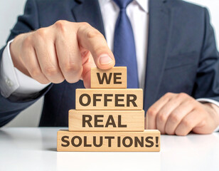 Obraz premium We offer real solutions! - Geschäftsmann zeigt auf den Text 