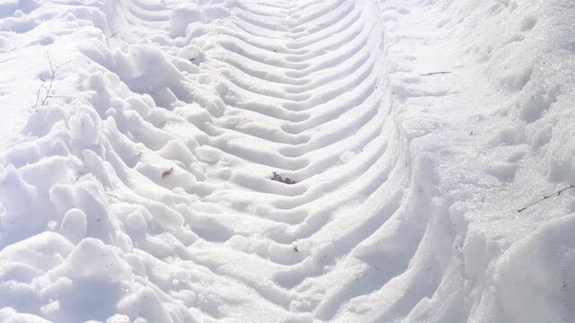 A close-up of truck tire tracks. Deep tire marks from a heavy vehicle in the snow. Winter background.