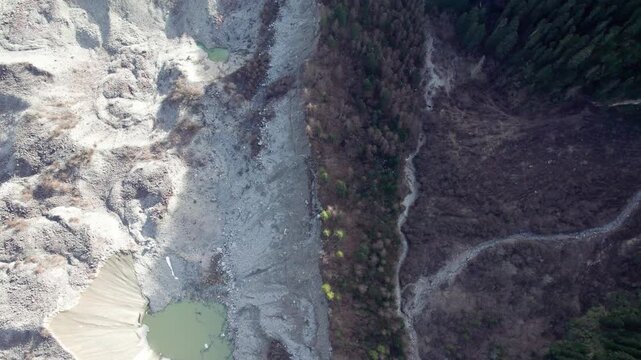 Drone view of Zhuxi glacier in Bomi County, Nyingchi, Tibet, China. High angle view of beautiful green glacial barrier lake among forest and gray rock, 4k real time footage b roll shot, travel concept