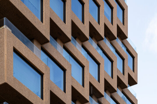 Modern architecture facade with concrete windows and geometric pattern creating abstract repetition and perspective in a strong urban composition