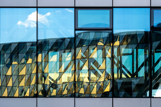 Modern blue glass facade where architecture windows and reflection create a geometric abstract pattern in a crisp contemporary detail