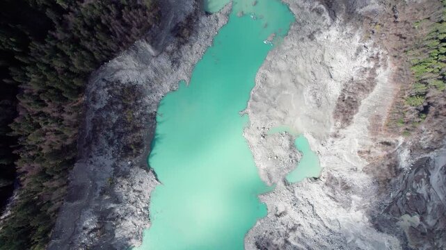 Drone view of Zhuxi glacier in Bomi County, Nyingchi, Tibet, China. High angle view of beautiful green glacial barrier lake among forest and gray rock, 4k real time footage b roll shot, travel concept