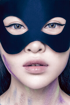 Asian woman wearing a bat mask