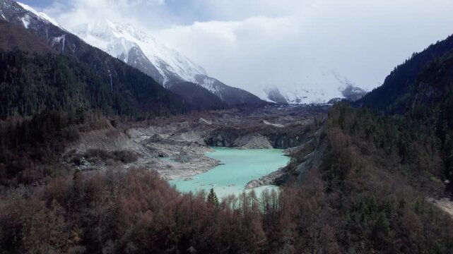 Drone view of Zhuxi glacier in Bomi County, Nyingchi, Tibet, China. High angle view of beautiful green glacial barrier lake among forest and gray rock, 4k real time footage b roll shot, travel concept
