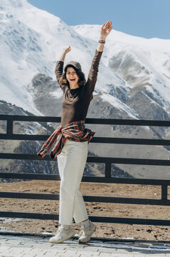 Happy tourist smiling and cheering in snowy mountain landscape