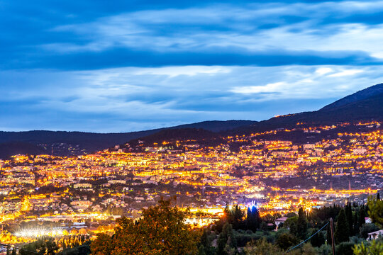 Illuminated evening cityscape of Grasse France against mountains