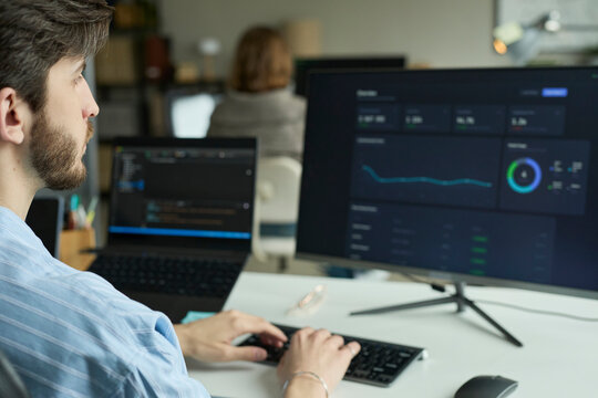 Employee analyzing financial chart on digital screen in office