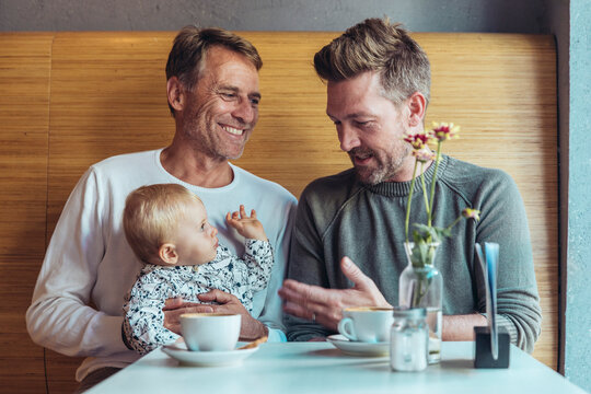 Couple spending time with baby at cafe showing love and family bond