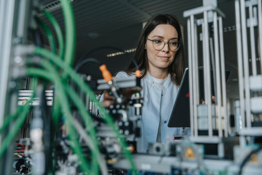 Scientist analyzing sortation machine in laboratory with green cables