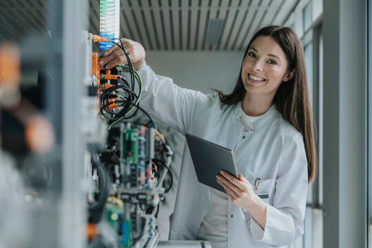 Scientist in laboratory operating machine and recording data