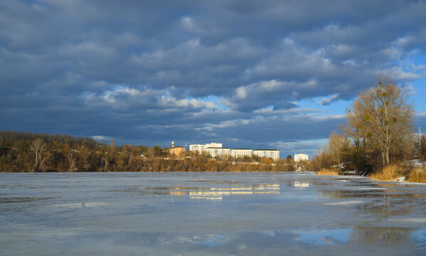 Melting frozen lake in spring near cityscape in Bucha Ukraine