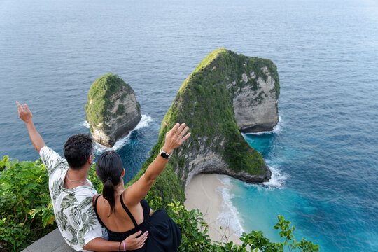 Romantic couple enjoy the ocean view from cliff in Nusa Penida