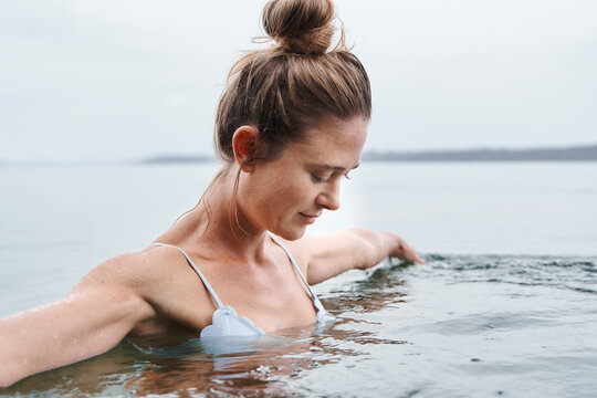 Beautiful woman with arms outstretched swimming in lake