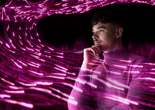 Innovator thinking amidst glowing pink digital data trails