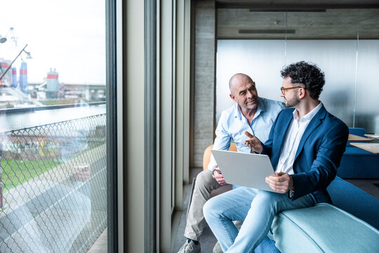 Smiling businessman with notebook brainstorming during office meeting