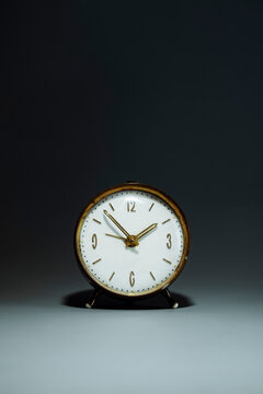 Vintage analog alarm clock on a dark grey background