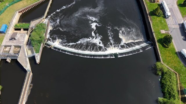 Top down aerial view of Knottingley Weir with cascading water and center fish passage notch UK